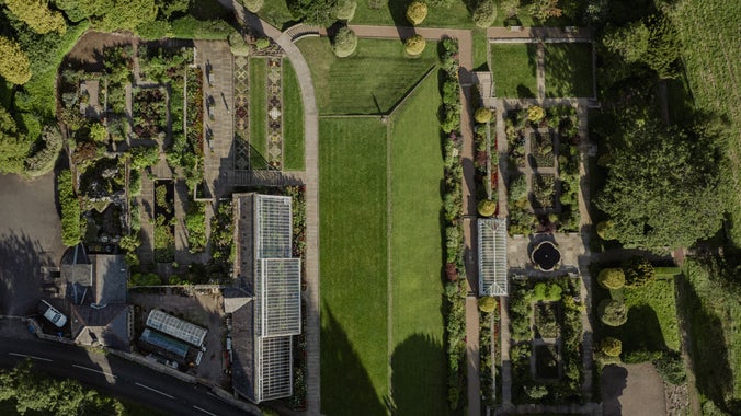 A drone shot of the Formal Garden showing sculpted lawns and precise patterns in the flower beds.